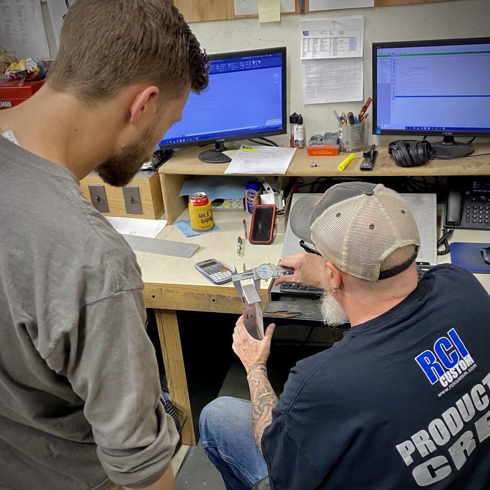 two men measuring at workbench